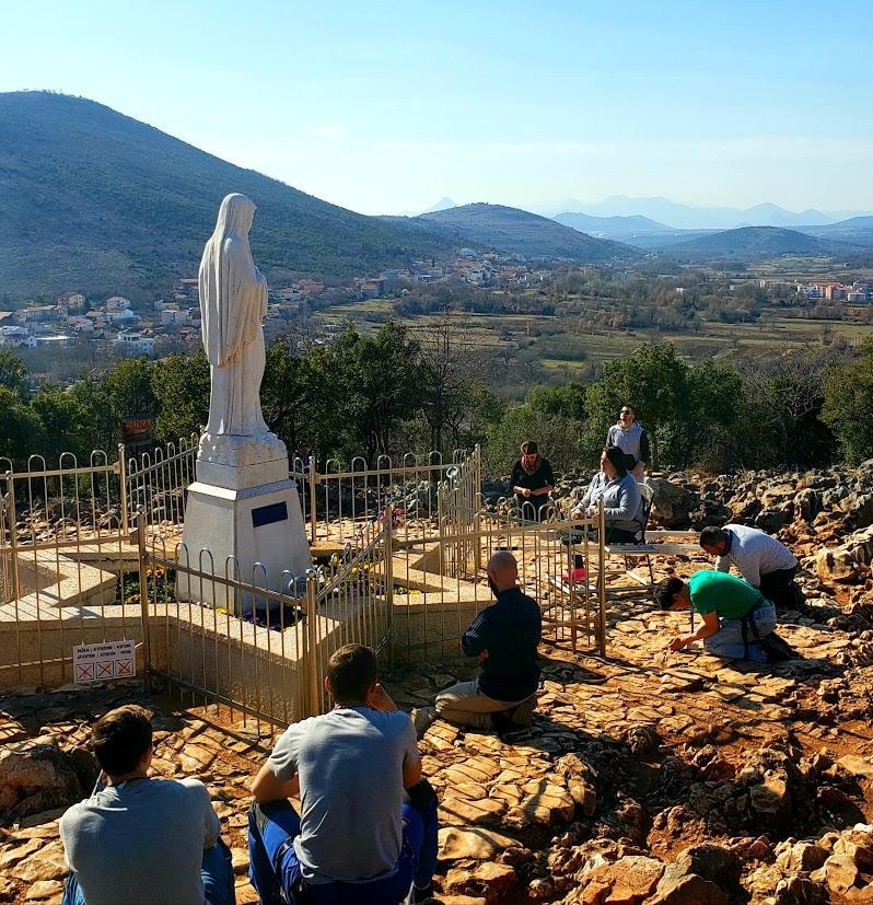 Pilgrims praying at Apparition Hill in Medjugorje